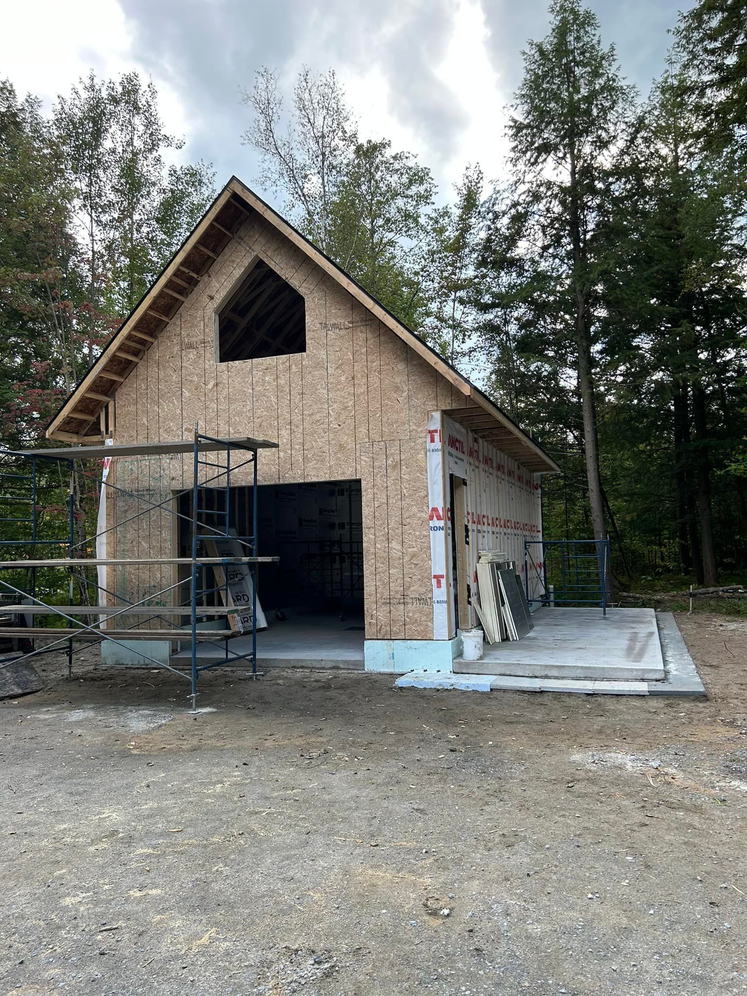 Un garage est en construction au milieu d'une forêt.