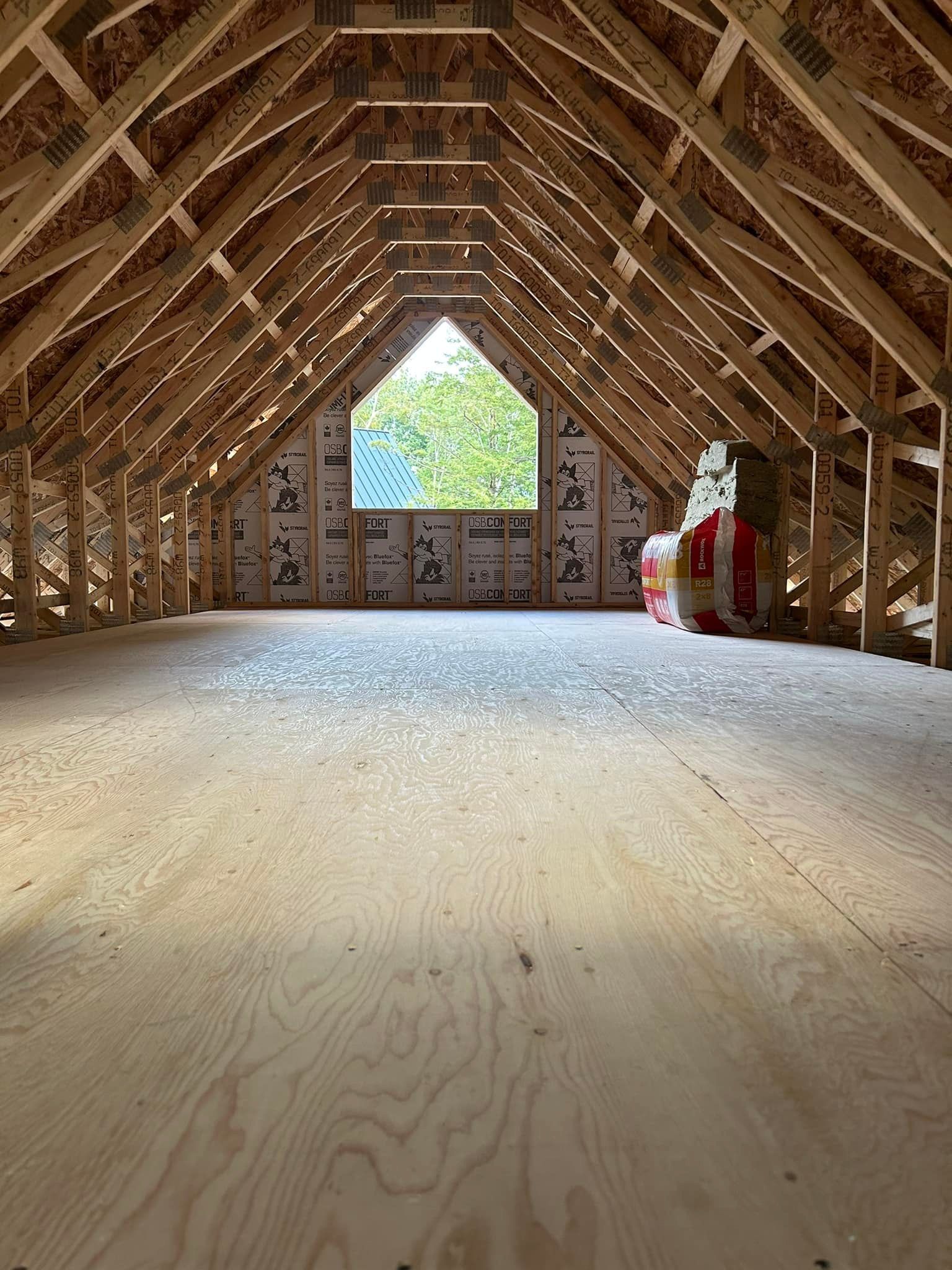 Le grenier d'une maison en construction avec une fenêtre au plafond.