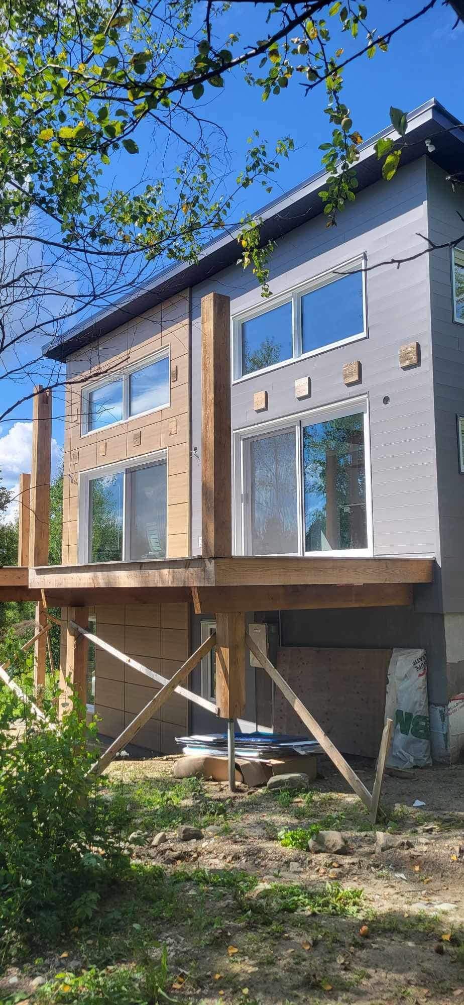 Une maison est en construction sur pilotis avec une grande terrasse.