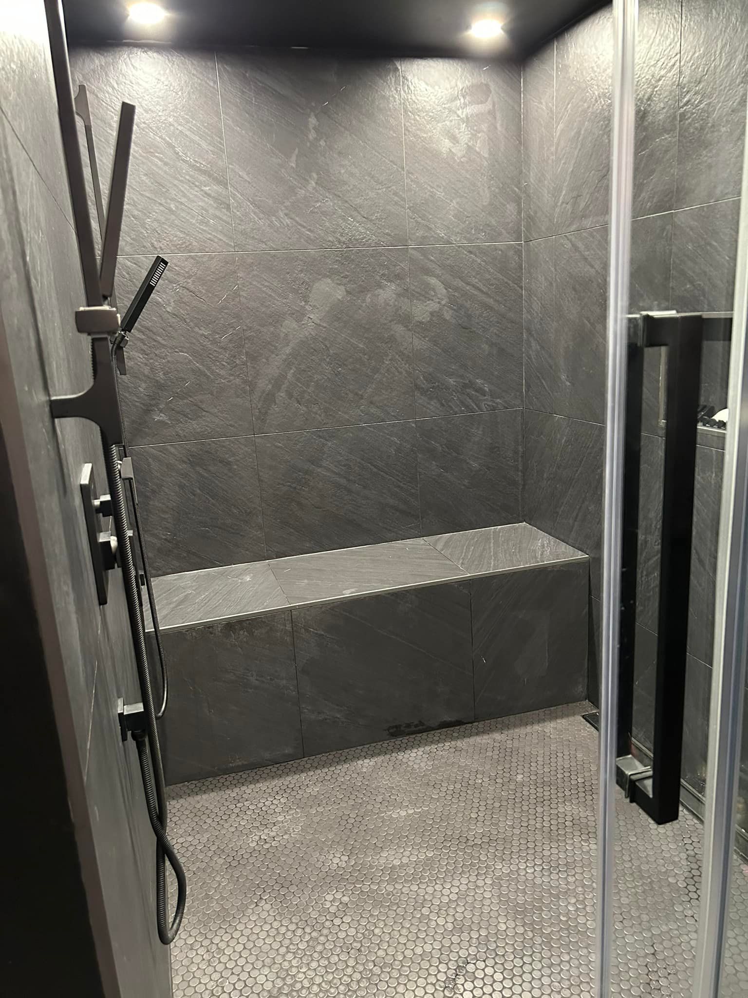 Une salle de bain avec une douche et un banc dedans.