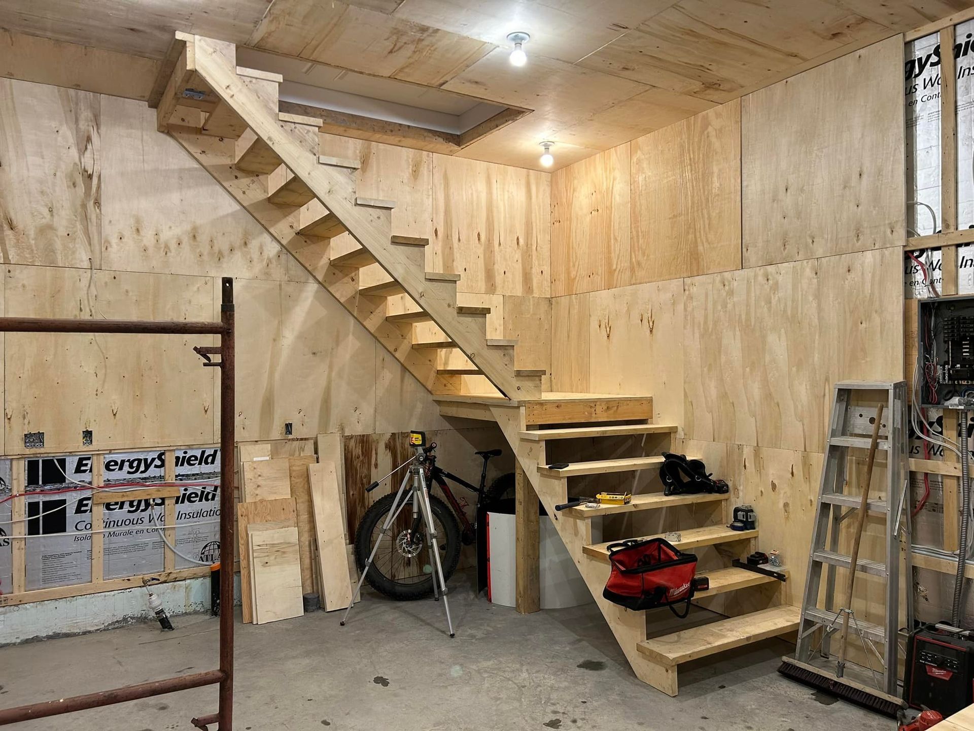 Un escalier en bois est en cours de construction dans un garage.