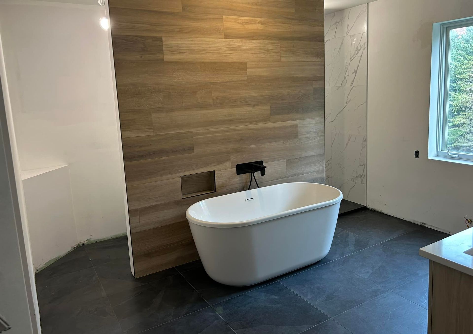 Il y a une baignoire au milieu de la salle de bain.