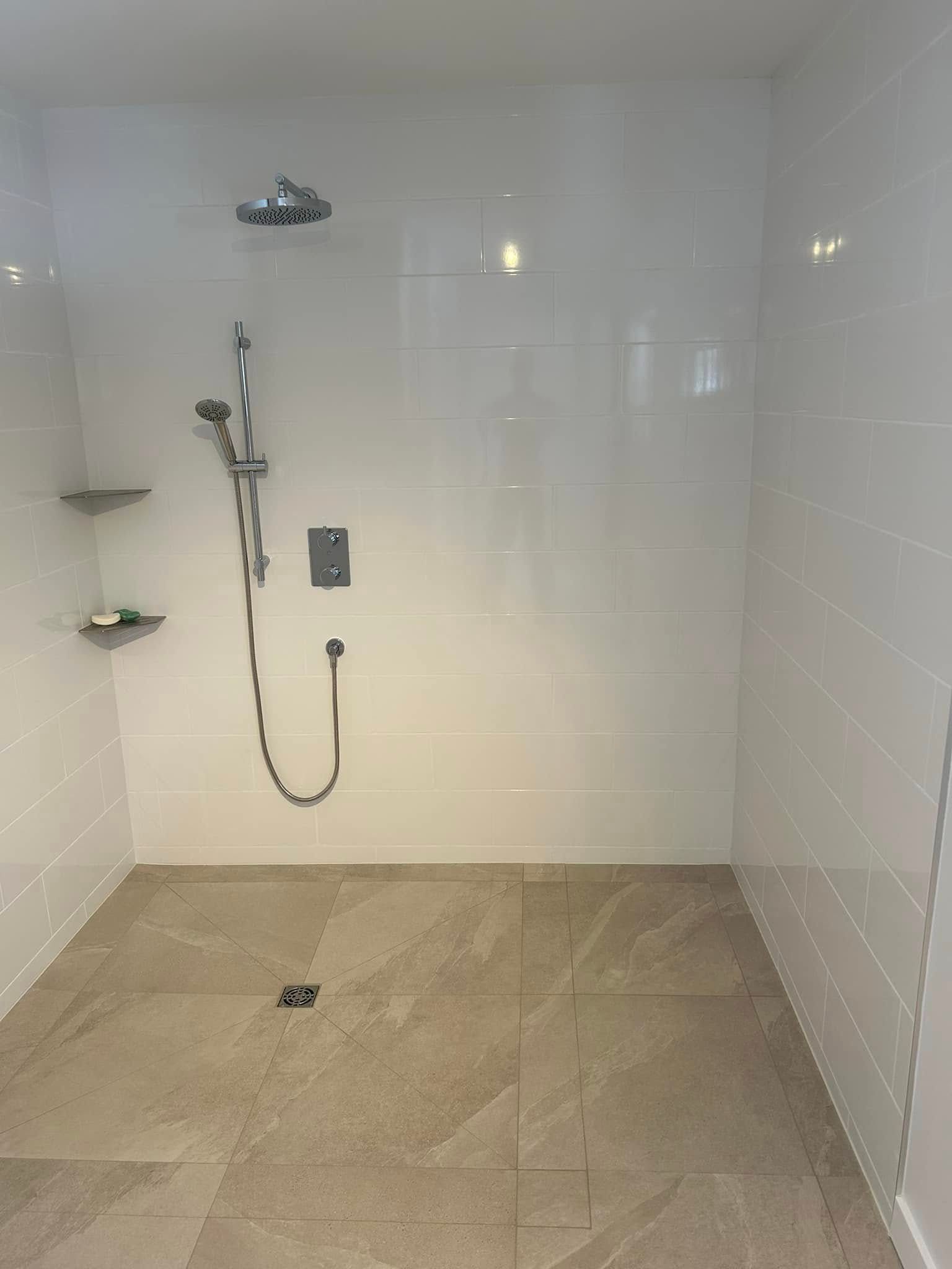 Une salle de bain avec douche à l'italienne et pommeau de douche.
