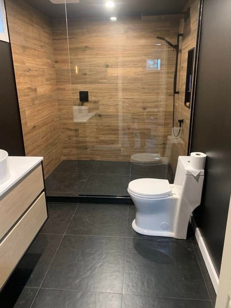 Une salle de bain avec WC, lavabo et douche à l'italienne.