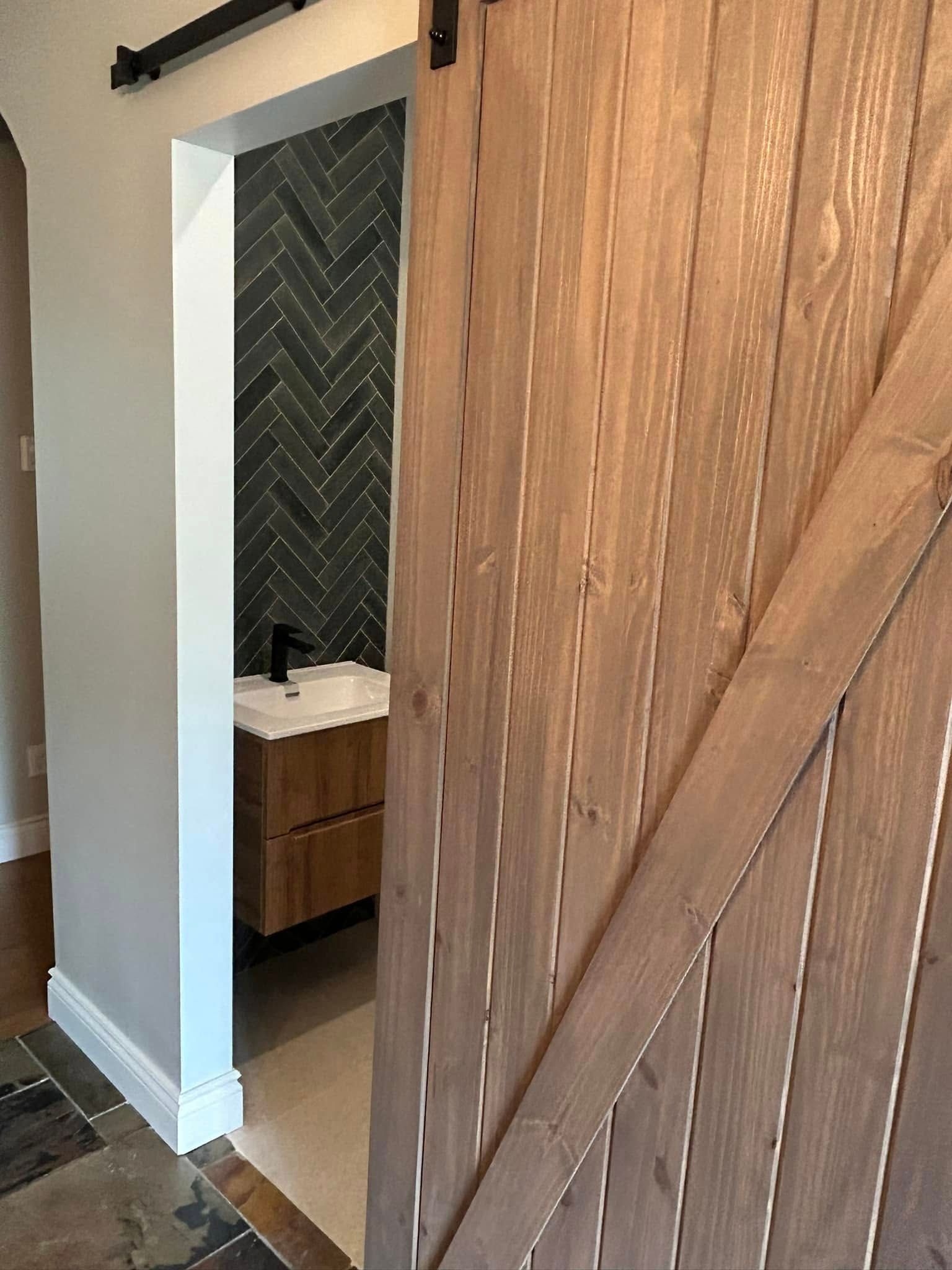 Une salle de bain avec une porte de grange coulissante qui y mène.