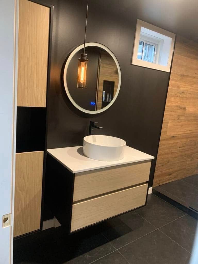 Une salle de bain avec un lavabo, un miroir et des tiroirs.
