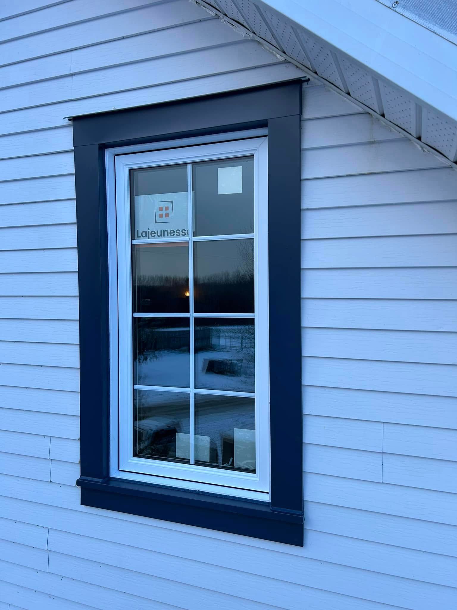 Une fenêtre sur le côté d'une maison blanche