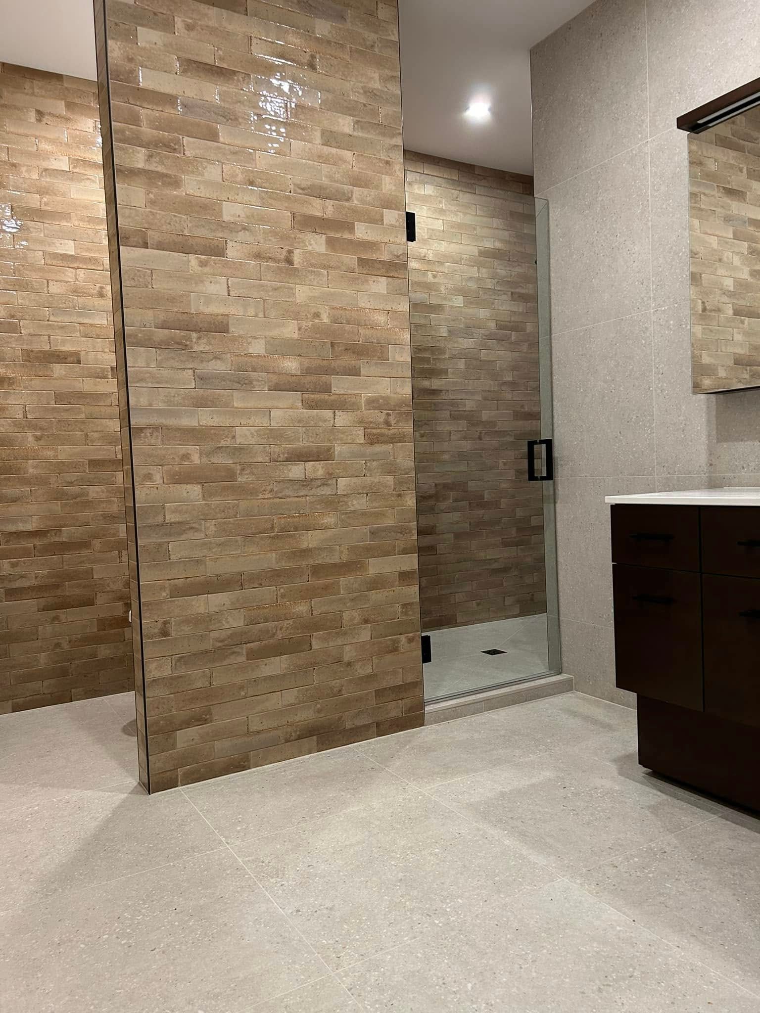 Une salle de bain avec lavabo, miroir et douche.