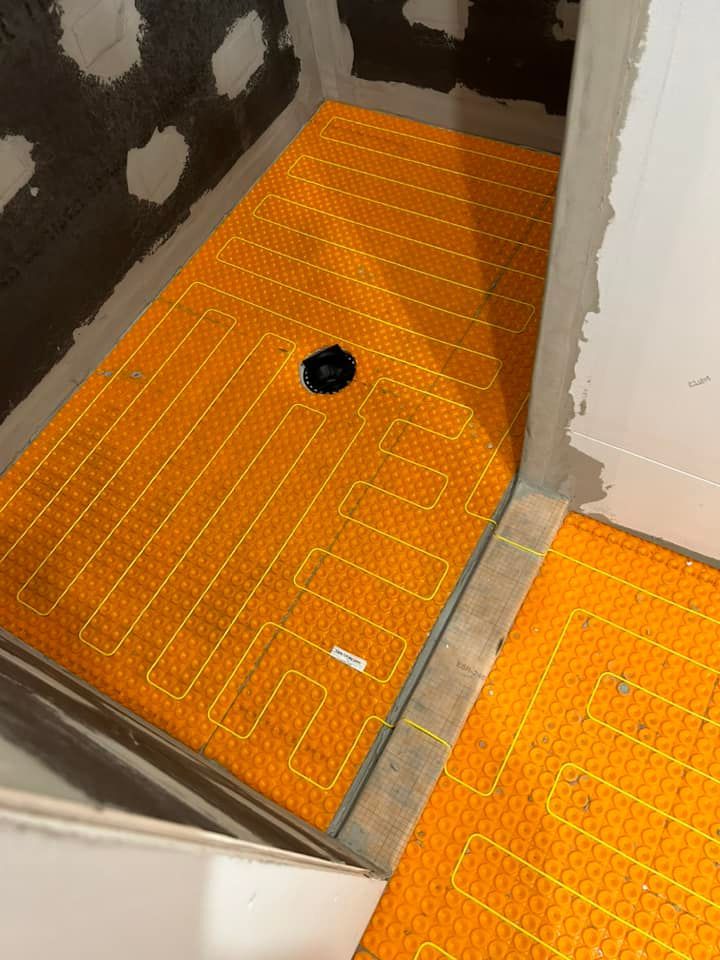 Une cabine de douche avec un tapis jaune sur le sol.