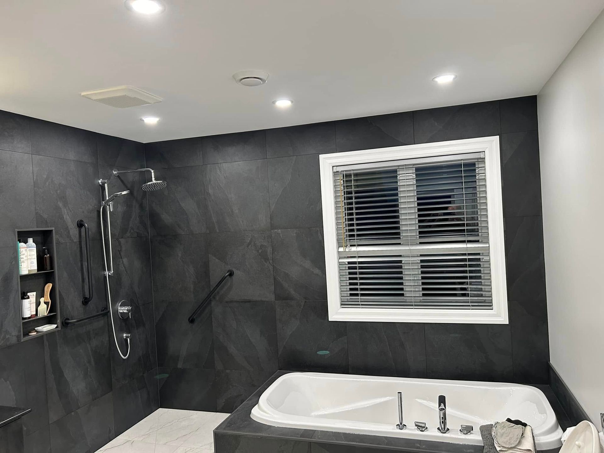 Une salle de bain avec baignoire, douche et fenêtre.
