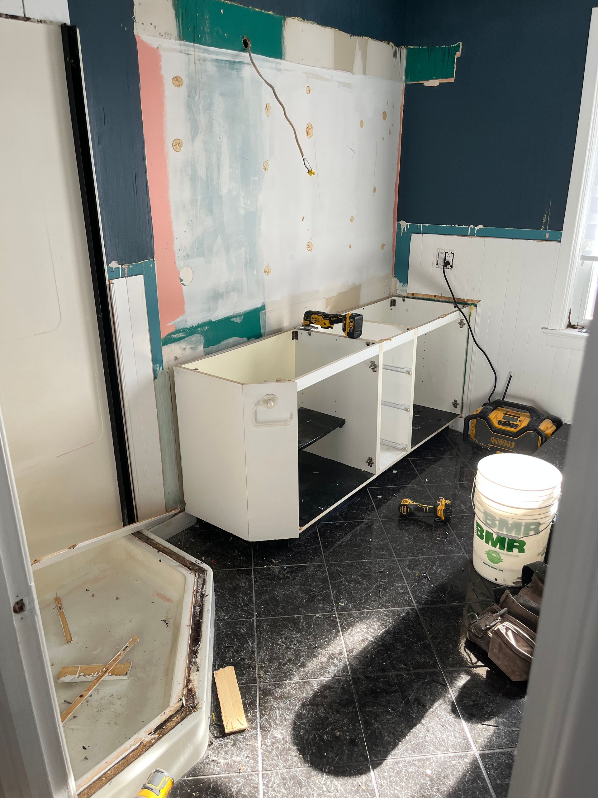Une salle de bain en construction avec un lavabo et un pot de peinture.