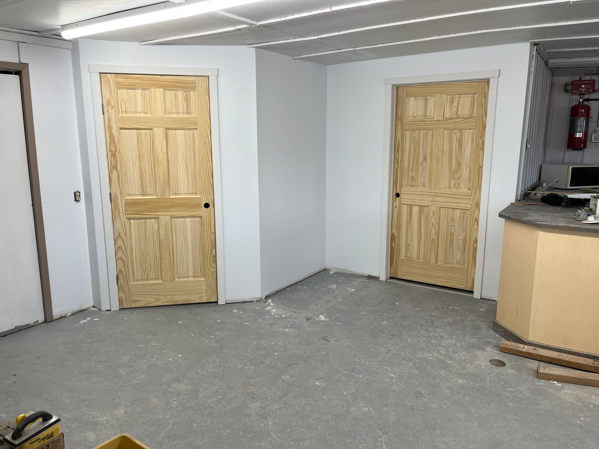 Une pièce avec deux portes en bois et un comptoir.
