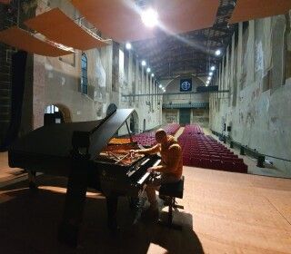 Un uomo sta suonando il pianoforte in un grande auditorium.