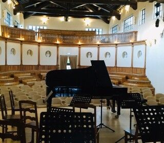 Un auditorium vuoto con un pianoforte al centro