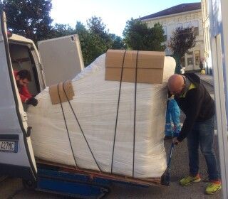 Un uomo sta caricando un oggetto di grandi dimensioni su un furgone.