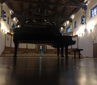 Un pianoforte è posizionato al centro di una grande stanza.