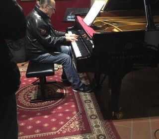 Un uomo è seduto su una sedia e suona il pianoforte.