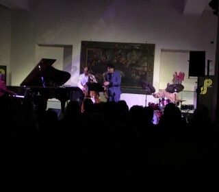 Un gruppo di persone suona uno strumento su un palco di fronte a una folla.