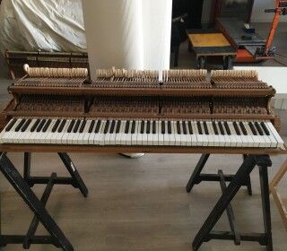 Una tastiera di pianoforte è appoggiata su un tavolo di legno.
