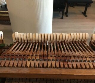 Un primo piano della tastiera di un pianoforte in un soggiorno.