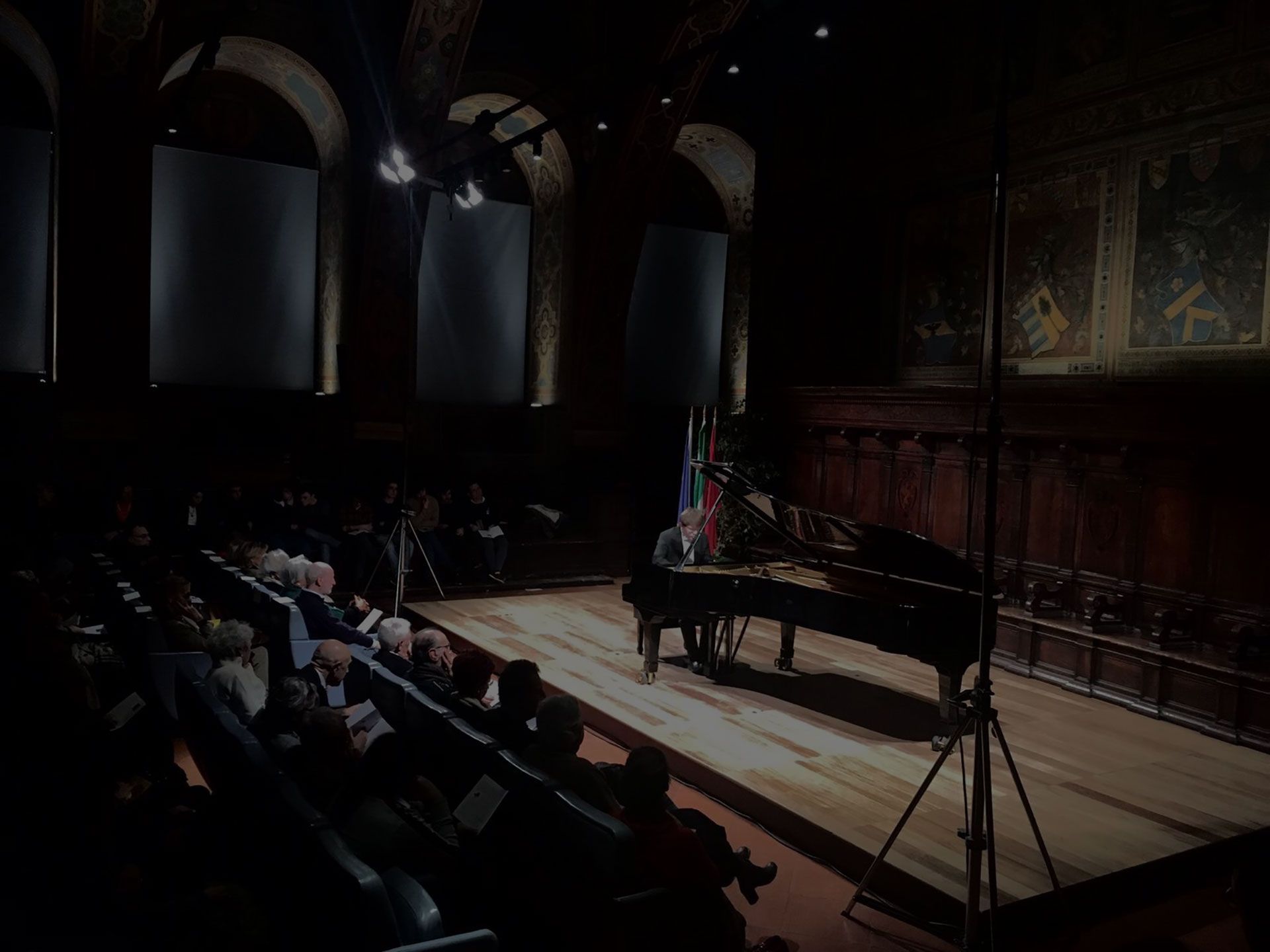 Un uomo sta suonando il pianoforte su un palco di fronte a una folla.