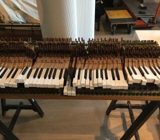 Una tastiera di pianoforte è appoggiata su un tavolo di legno.