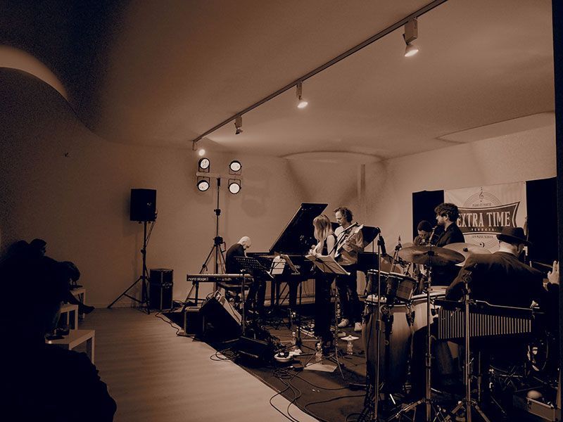 Una band sta suonando in una stanza con un cartello che dice tempo extra
