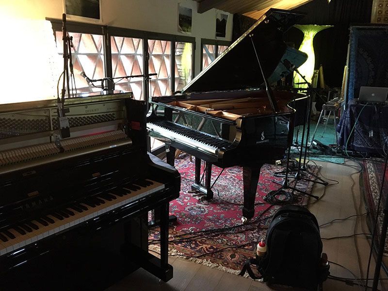 Un pianoforte è posizionato in una stanza accanto a una tastiera.