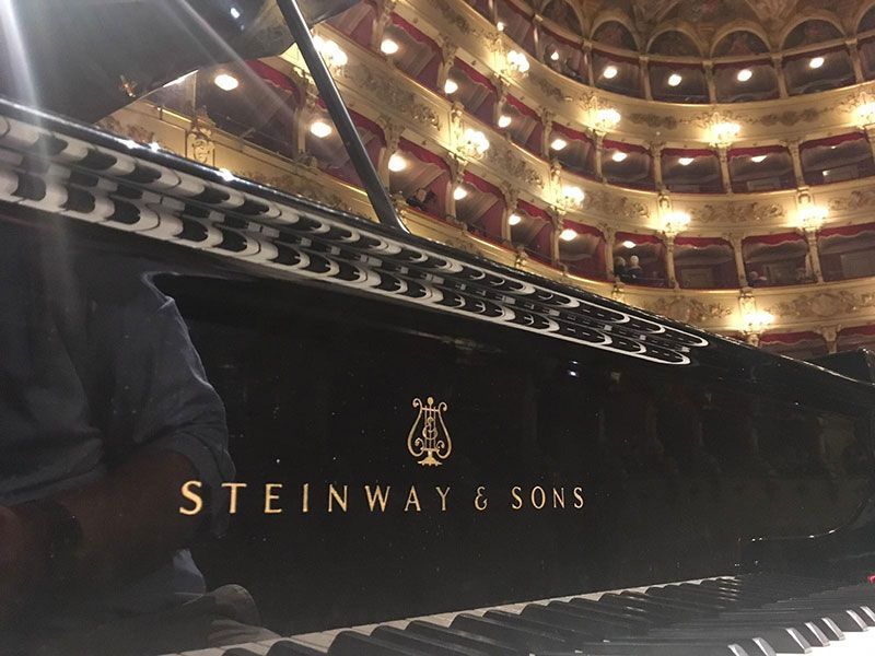 Un pianoforte steinway & sons davanti a un grande auditorium