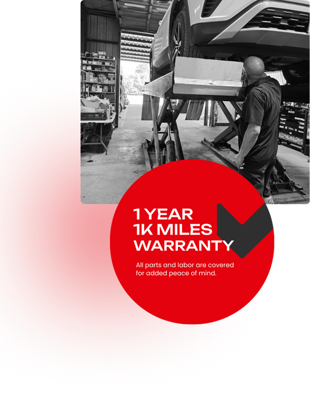 Mechanic working under a car hood with red warranty badge reading “1 year 10k miles warranty” | Pete's Automotive