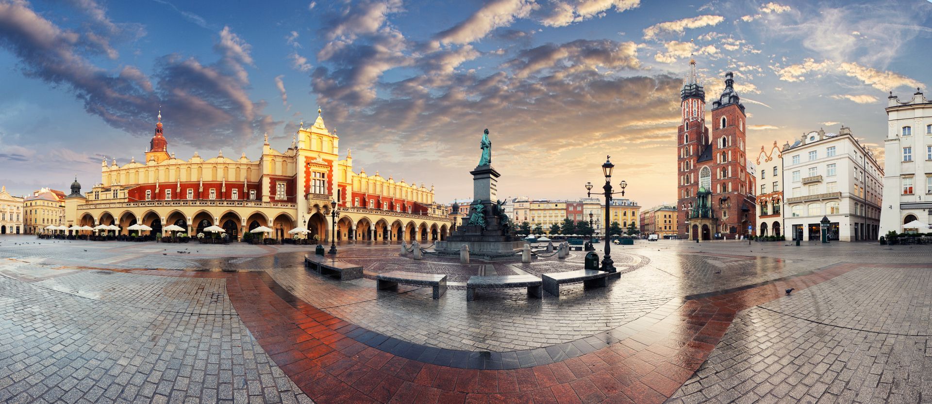Panoramic view of Krakow Main Market Square at sunset featuring the Cloth Hall and St. Mary's Basili