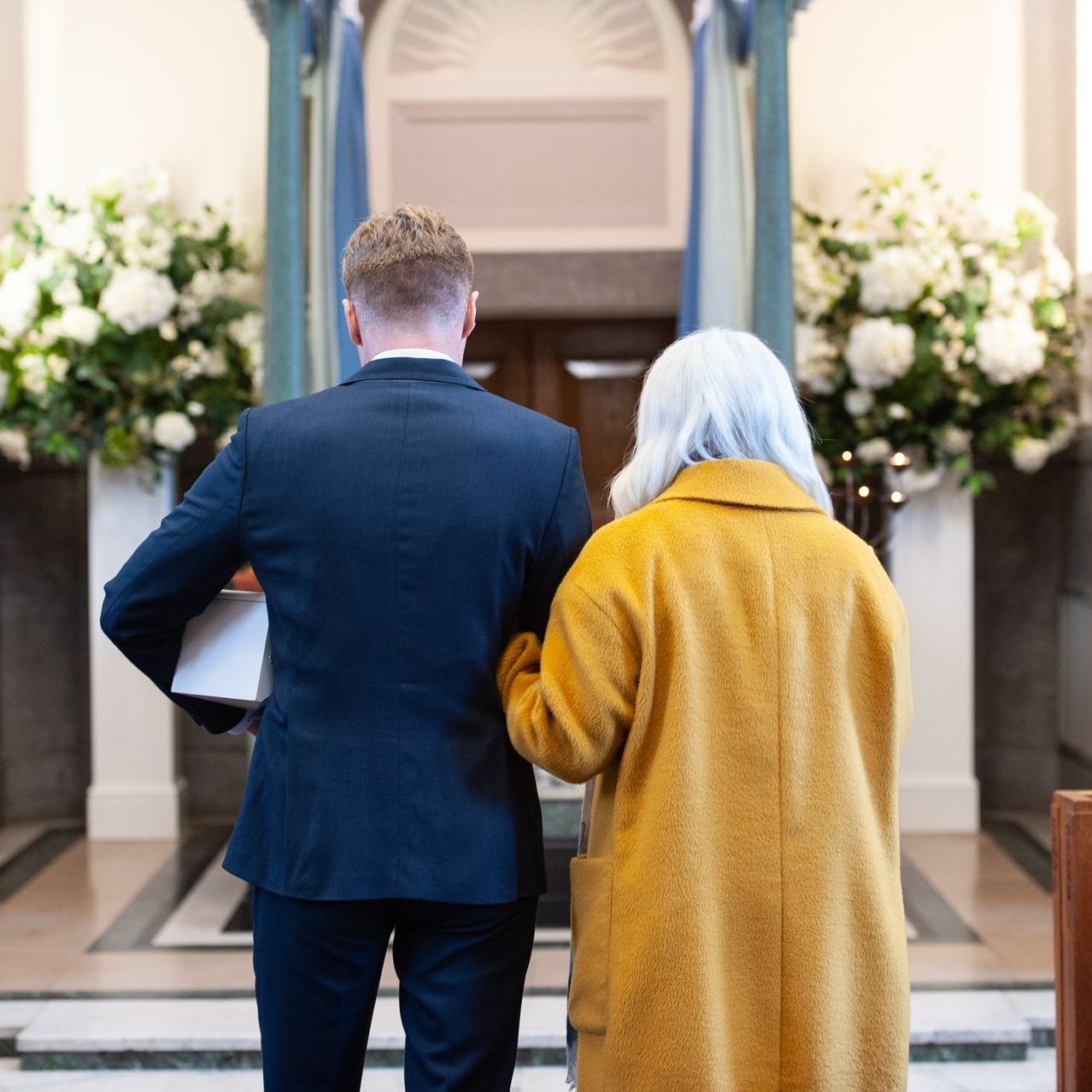 a man escorting an elderly woman into a church