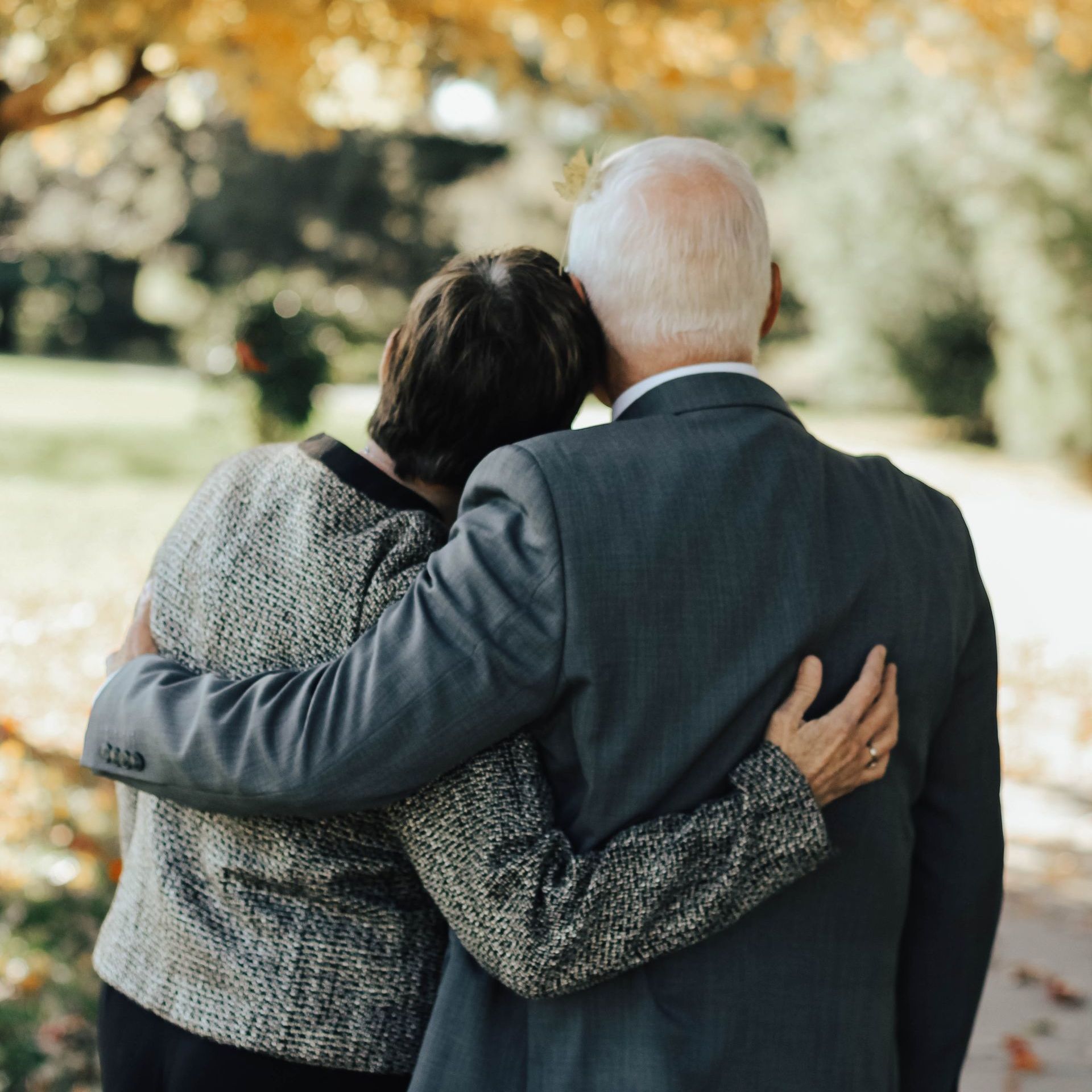 An elderly couple comforting each other