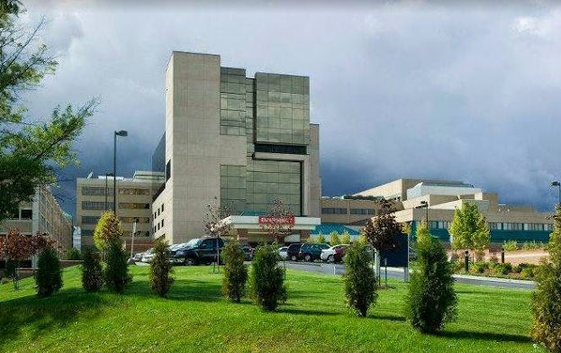 Outside view of hospital building, Munson Medical Center, with a lot of windows is surrounded by trees and grass.