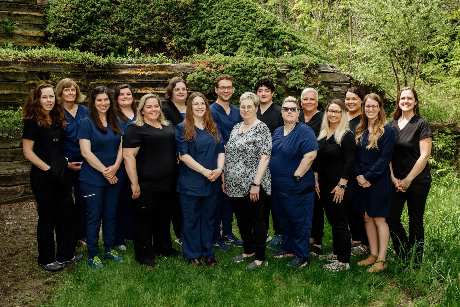Traverse Area Pediatric and Adolescent Clinic staff members standing outside in front of trees. 
