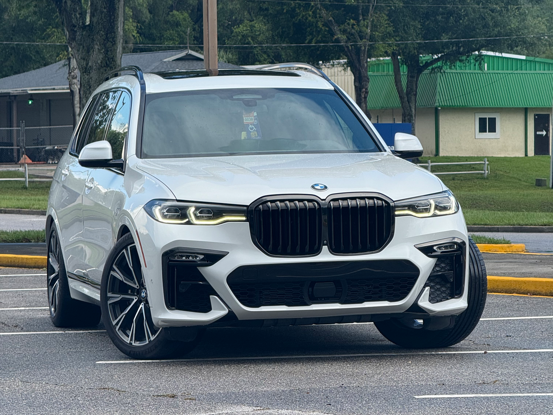 White BMW SUV parked in a lot, front view with black grille and silver trim