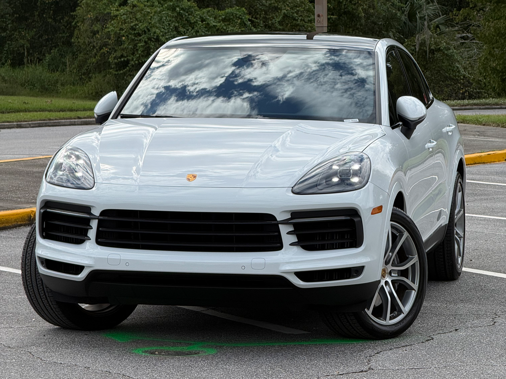 White SUV parked on a street, front view with black grille and silver wheels