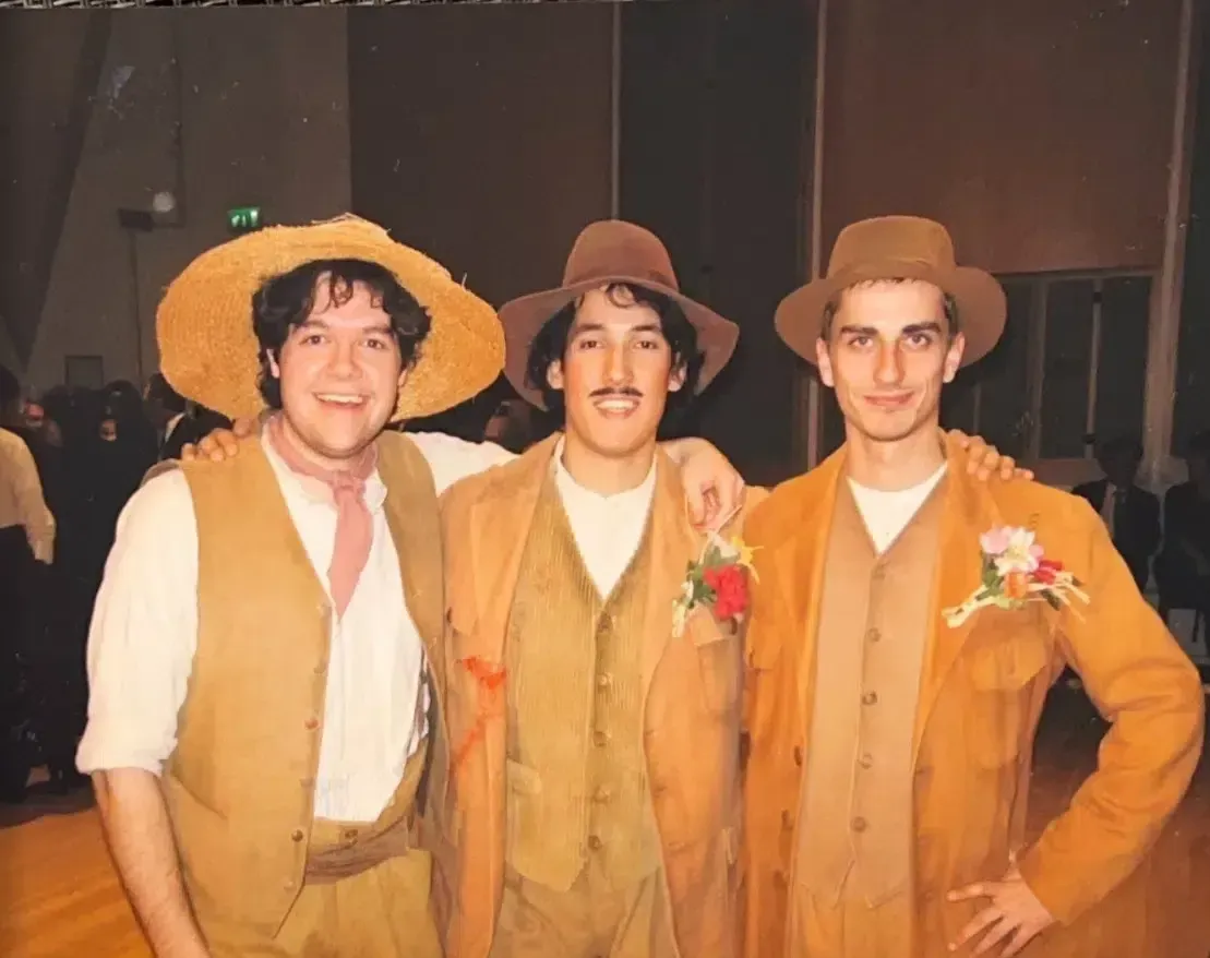 Tres hombres vestidos de vaquero posan para una fotografía