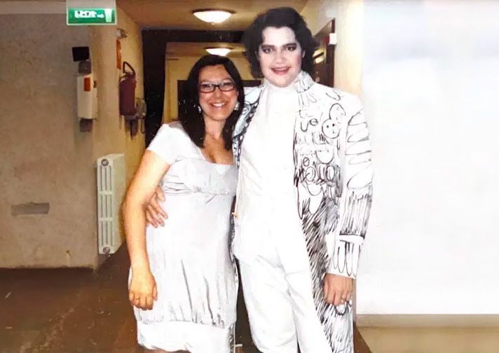 Un hombre con un traje blanco está junto a una mujer con un vestido blanco.