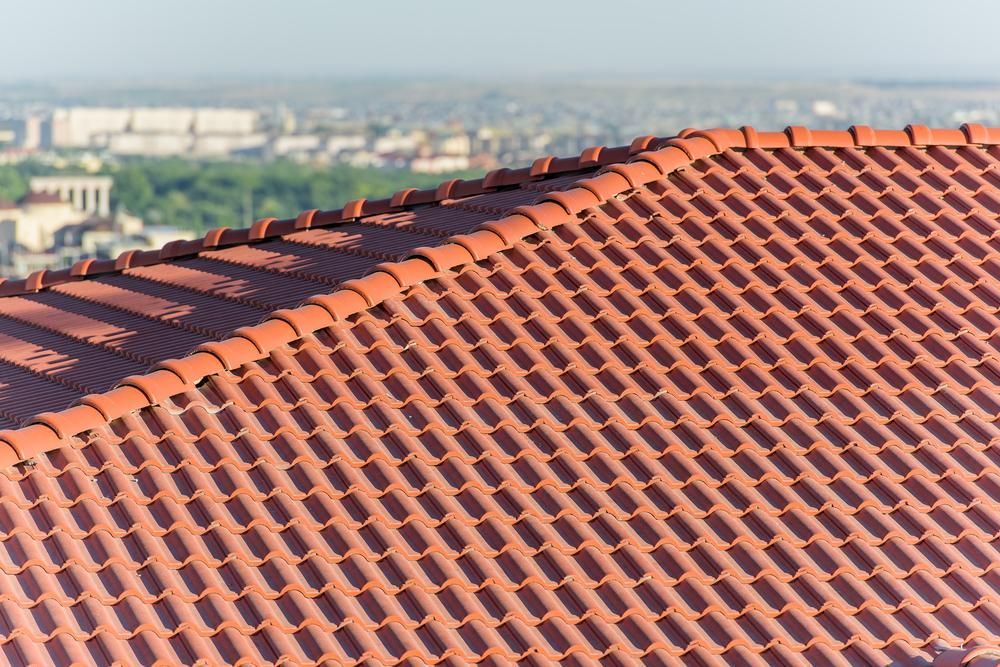 Red Tiled Roof With a City in the Blurred Background — Boostn Pty Ltd in Sunshine Coast, QLD