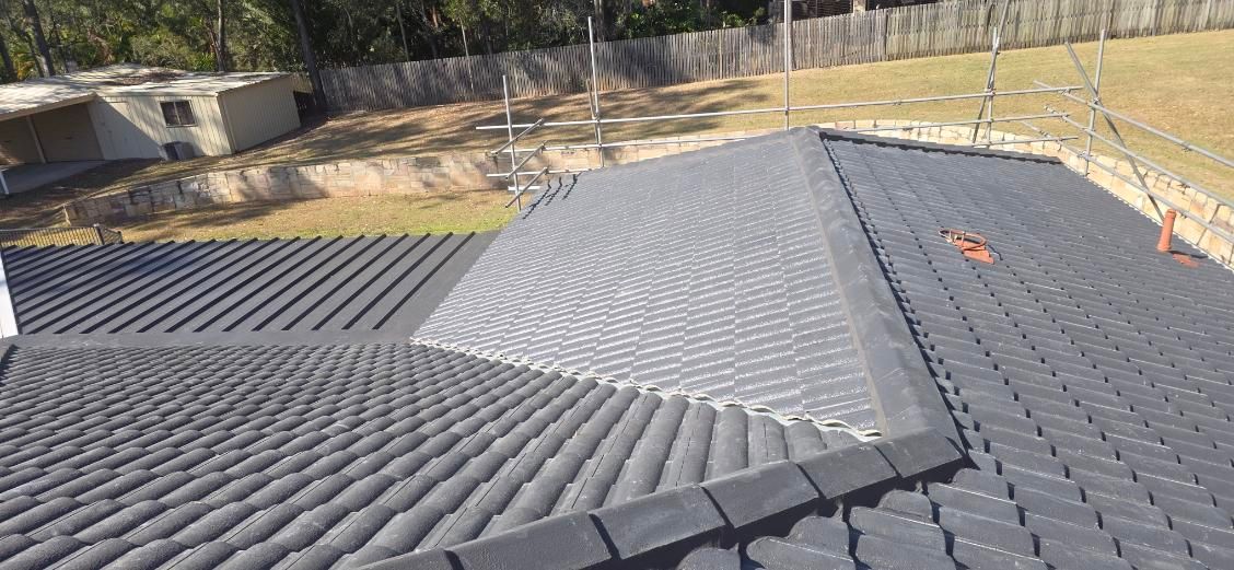 View from a roof shows dark gray tile shingles and a fenced yard. — Boostn Pty Ltd in Tin Can Bay, QLD