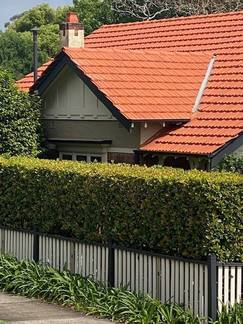 Wooden roof framework under construction with some finished tiles, against a blue sky. — Boostn Pty Ltd in Glastonbury, QLD