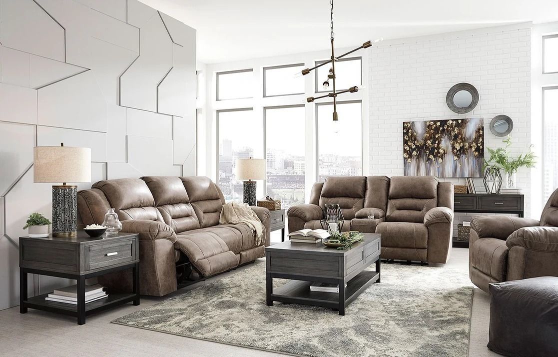 Living room with brown leather reclining furniture, gray rug, and abstract wall art.