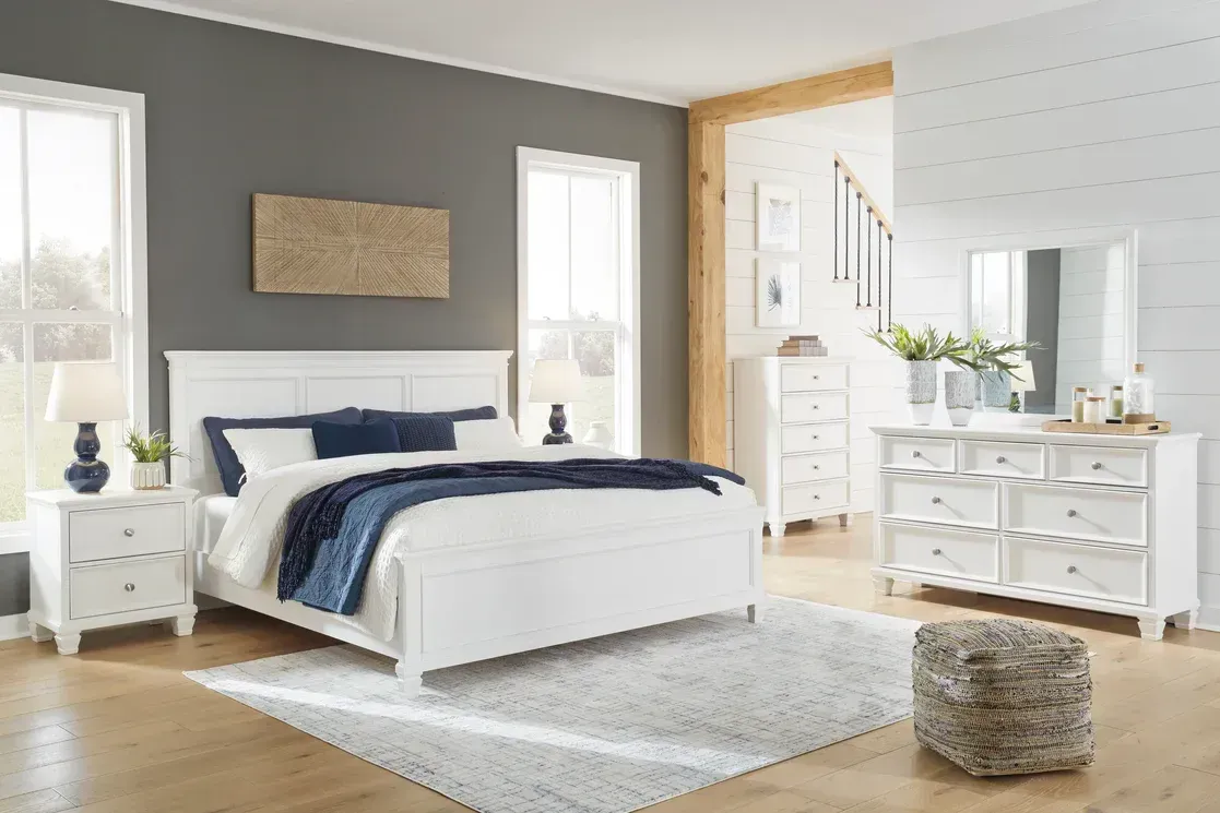 White bedroom furniture set in a room with gray walls and wood flooring.