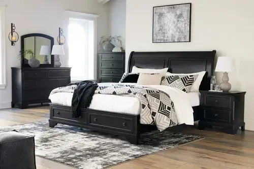 Black bedroom set: bed with storage, dresser, nightstand, chest, mirror, and a rug.
