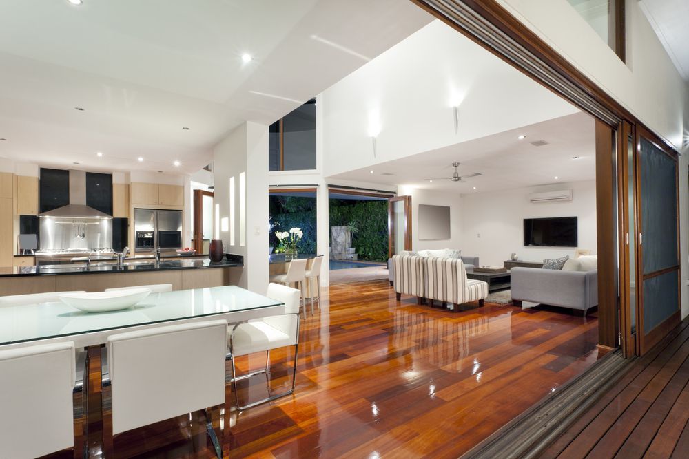 A living room with a dining table and chairs and a sliding glass door.