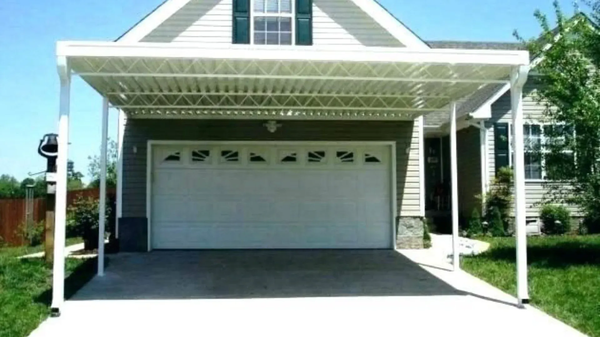 White carport attached to a house over a concrete driveway.