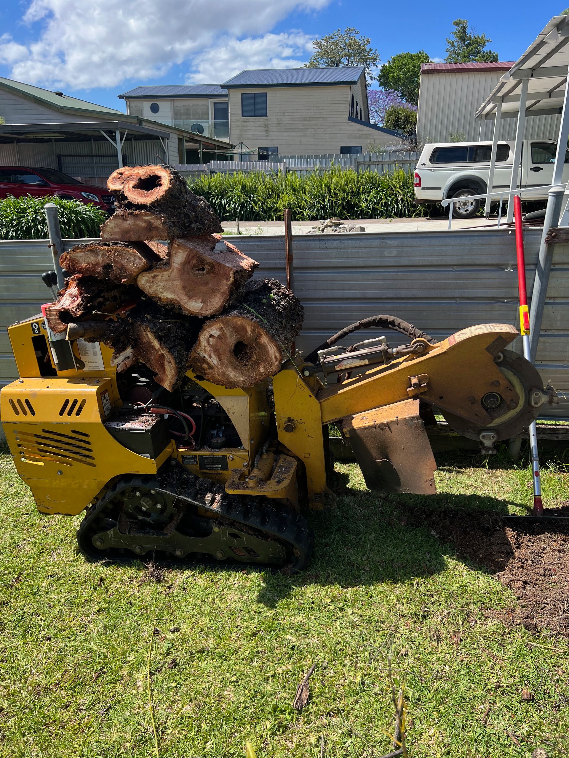 Green machine carrying a stump, on a clearing land process — Central Coast Tree Removal In Wyongah, NSW