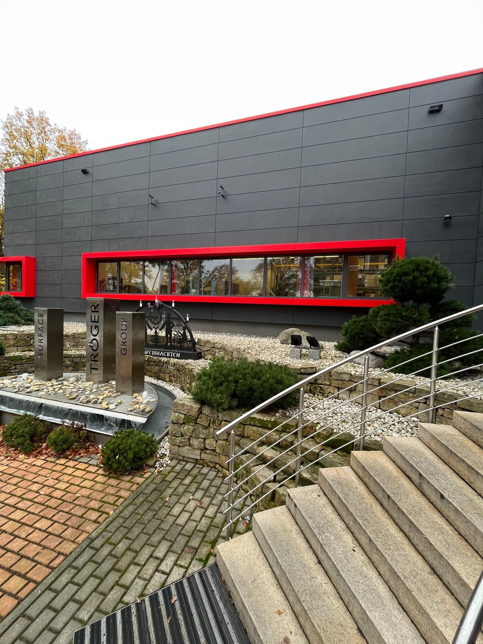 Sichtbetonfassade eines Geschäftshauses im Farbton Anthrazit verschönert mit Betonkosmetik  und imprägniert mit PolySealer der Firma rauMKult Sichtbeton