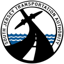 Circular logo of the South Jersey Transportation Authority featuring a black road, an airplane silhouette, and blue waves.